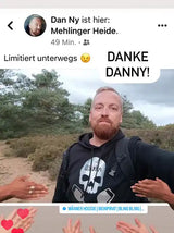 Ein bärtiger Mann trägt eine schwarze Kapuzenjacke mit einem weißen Totenkopf-Design.