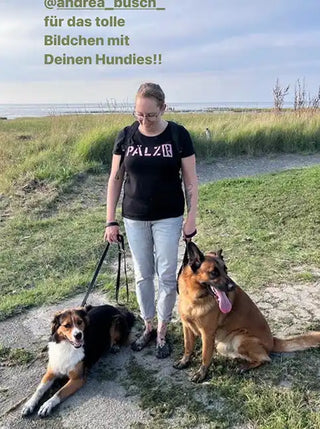 Frau, die zwei Hunde an Leinen führt.