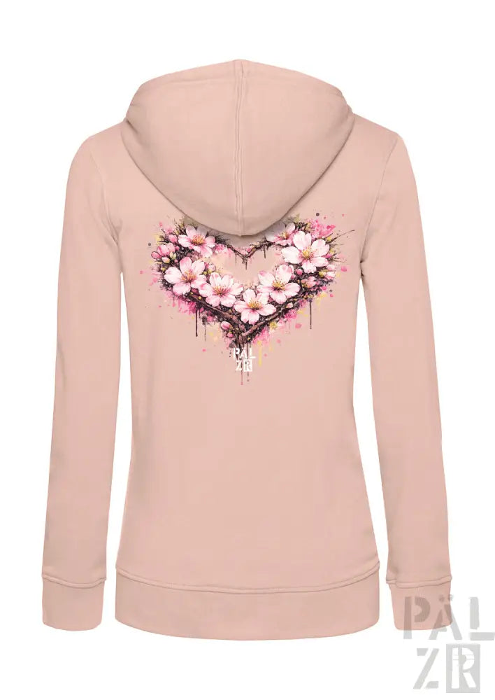 Ein weiches, zart rosafarbenes Damen-Hoodie mit einem lebendigen Aquarell-Herz-Design, das mit zarten Kirschblüten und subtilen Spritzeffekten verziert ist.