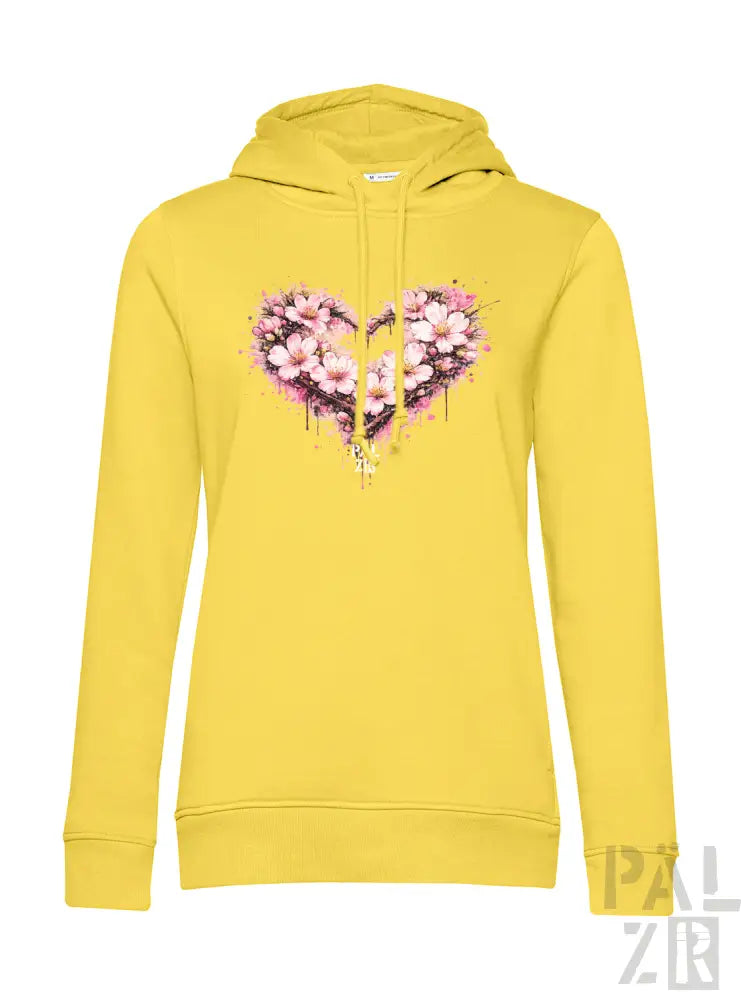 Ein lebendiges gelbes Damen-Hoodie mit einem herzförmigen Blumendesign mit pinken Blüten und Spritzfarbeffekten.