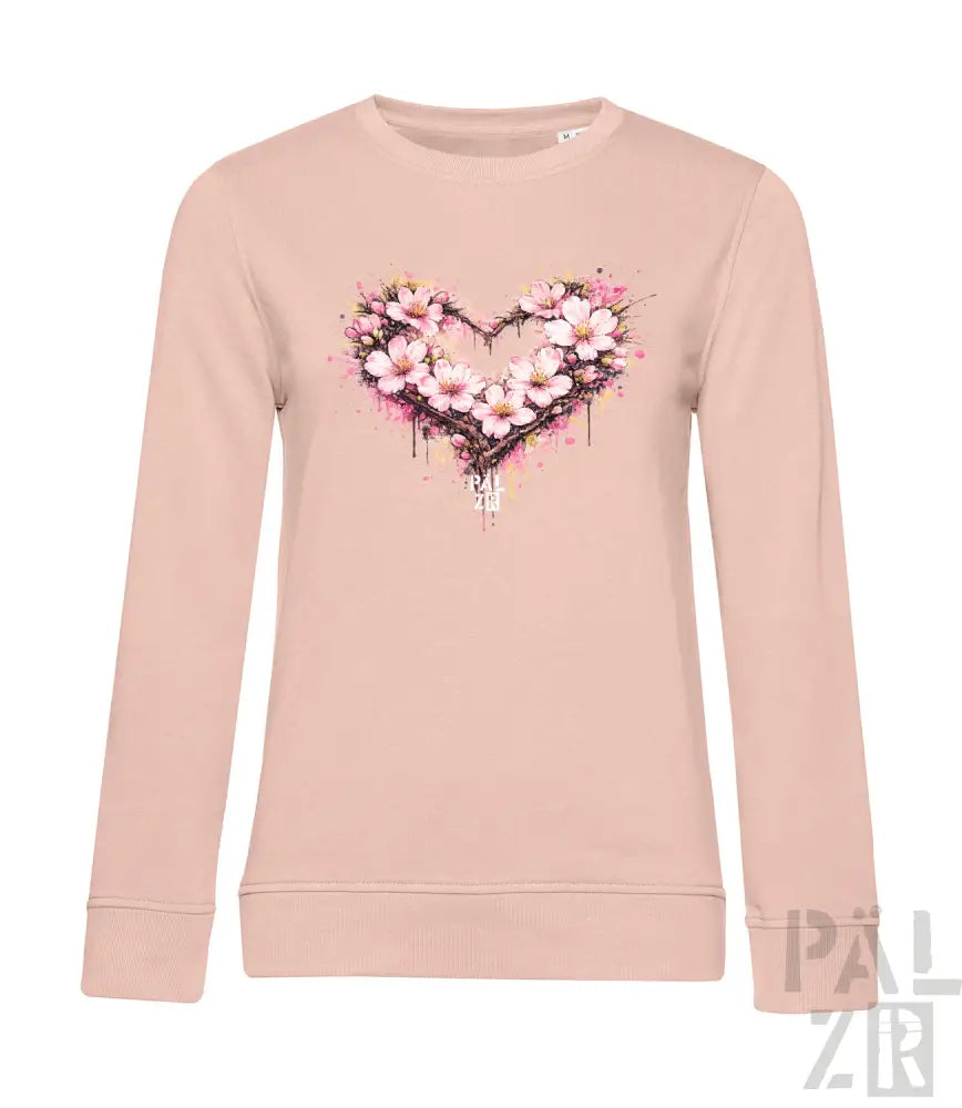 Ein weiches zartrosa Langarm-Sweatshirt mit einem lebendigen Aquarell-Herz-Design, das mit zarten weißen und rosa Blüten verziert ist.
