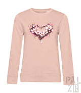 Ein weiches zartrosa Langarm-Sweatshirt mit einem lebendigen Aquarell-Herz-Design, das mit zarten weißen und rosa Blüten verziert ist.