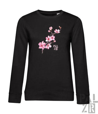 Schwarzer langärmliger frauenpullover mit zartem rosa mandelzweig und pal zr aufdruck in weiß