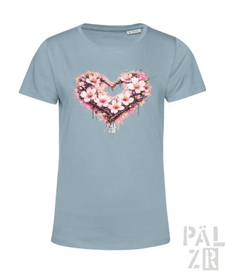 Hellblaues Damen-T-Shirt mit einem lebendigen pinken Kirschblüten-Herz-Design mit Spritzeffekten und dem ’pal zib’-Logo darunter.