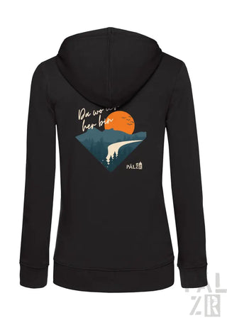Schwarze Damen-Zip-Hoodie mit farbenfrohem Grafikmotiv einer orangenen Sonne über Bergen und Bäumen sowie dem Text ‚da wo wir her bin‘ gedruckt darüber.