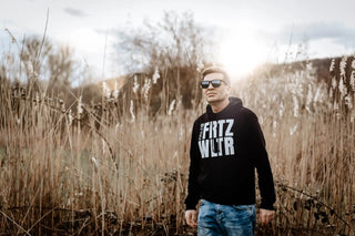 Schwarzes Hoodie mit weißem Text „frtz wltr“ und Sonnenbrille.