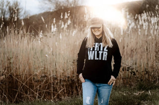 Schwarzes ’frtz wltr’ Hoodie mit abgetragenen Denim-Jeans und einer beigen Kappe.