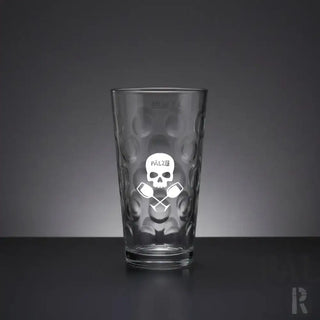 Klares Glas-Pint-Glas mit einer texturierten, eingedrückten Oberfläche und einem geätzten weißen Totenkopf-Logo, darunter gekreuzte Ruder.