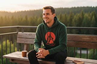 Grüner Hoodie mit einem rot-orange grafischen Design, das zwei Figuren auf der Vorderseite zeigt.