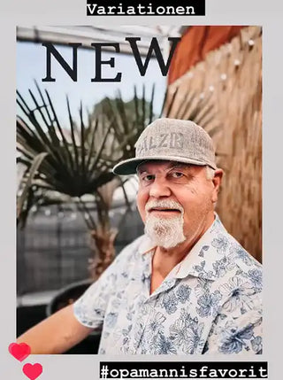 Eine hellfarbene Baseballkappe mit einem dunklen Schirm und gesticktem Text.