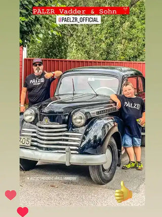 Ein vintage schwarzes Auto mit einem auffälligen Chromgrill.