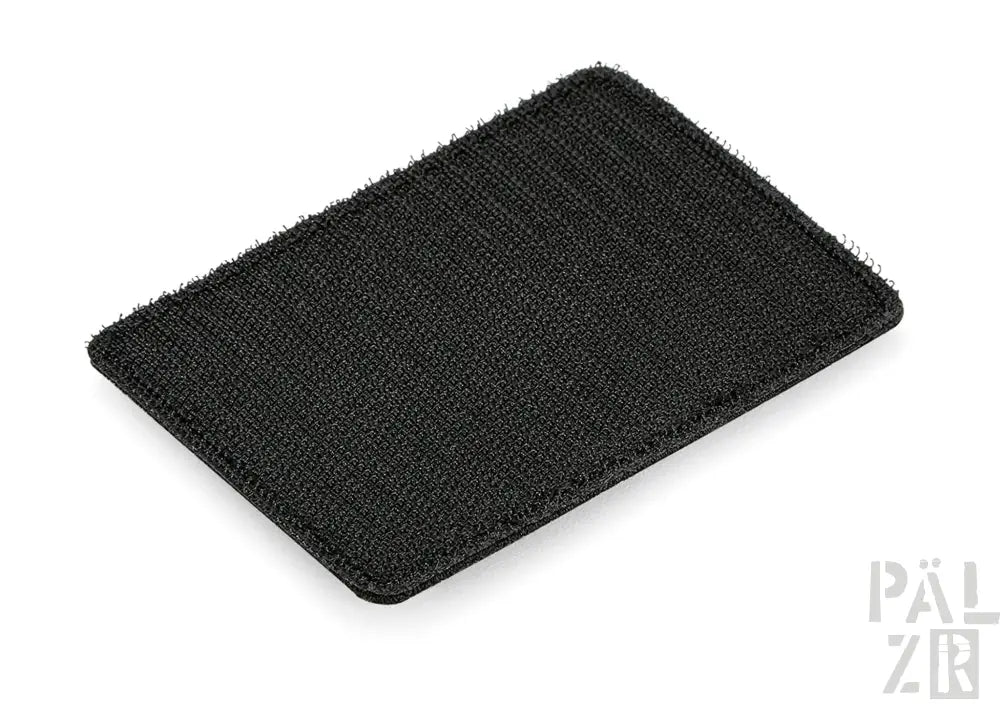 Schwarze texturierte Autofußmatte mit gerippten Rändern und Klettverschluss-Rückseite.