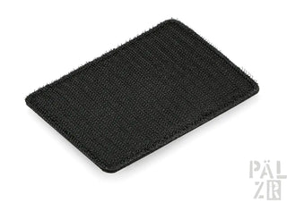 Schwarze texturierte Autofußmatte mit gerippten Rändern und Klettverschluss-Rückseite.