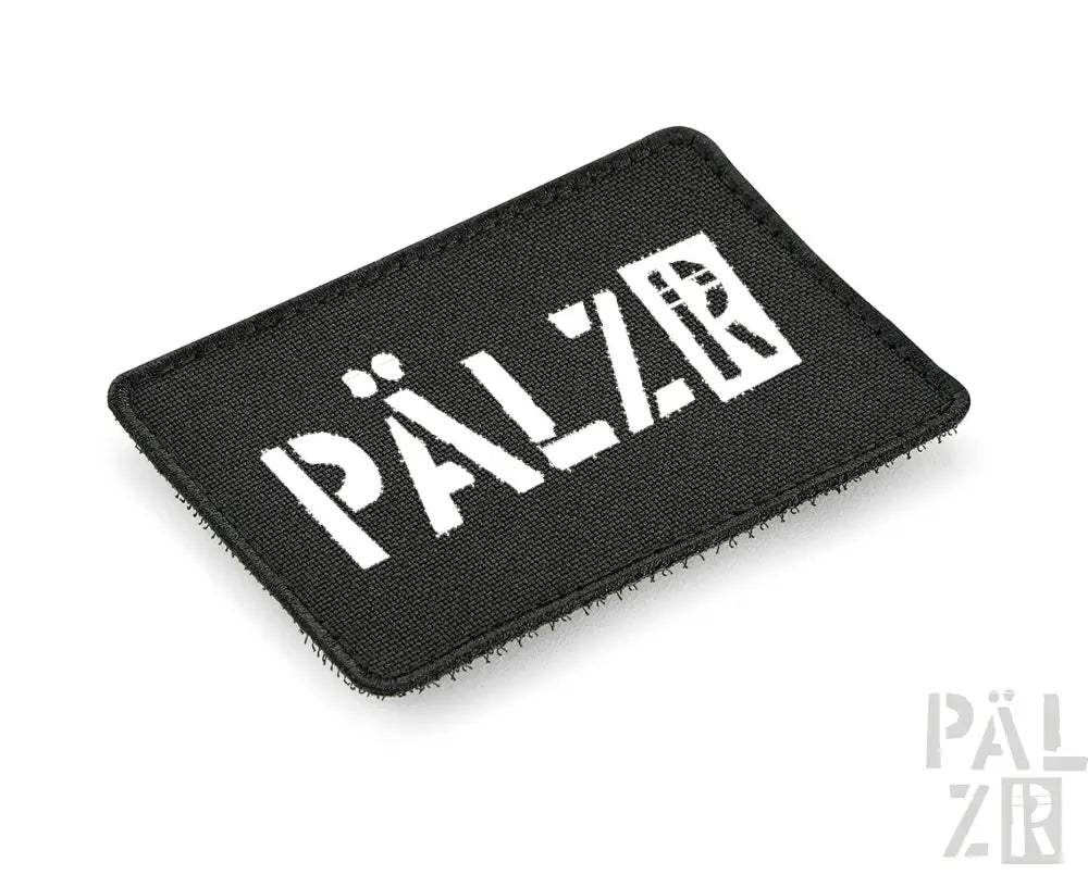 Schwarzer rechteckiger Aufnäher mit weißem Text und Design, wahrscheinlich aus Stoff oder synthetischem Material gefertigt.