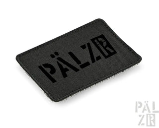 Schwarzer taktischer Patch mit ‚pälzar‘-Text und Logo-Design.