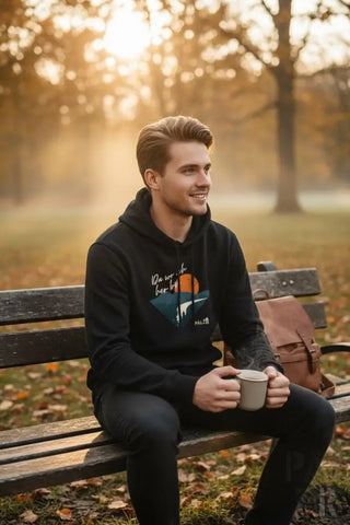 Schwarzer Hoodie mit einem farbenfrohen Grafikdruck, der eine orange Sonne und Bergsilhouette zeigt, mit der Marke »halt« in weißer Schrift darunter.