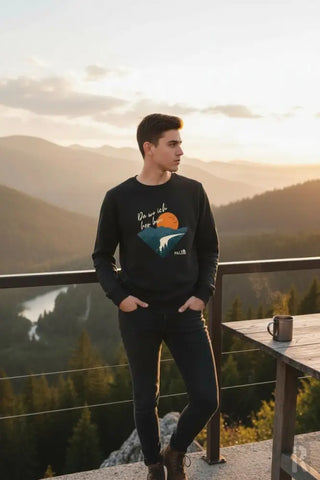 Schwarzes Langarm-Sweatshirt mit grafischem Druck einer orangenen Sonne über blauen Bergen und weißem kursivem Text darüber