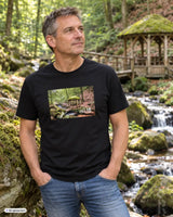 Schwarzes männer t-shirt aus baumwolle mit rechteckigem print eines moosbedeckten pavillons an einem bach und weißem palz schriftzug