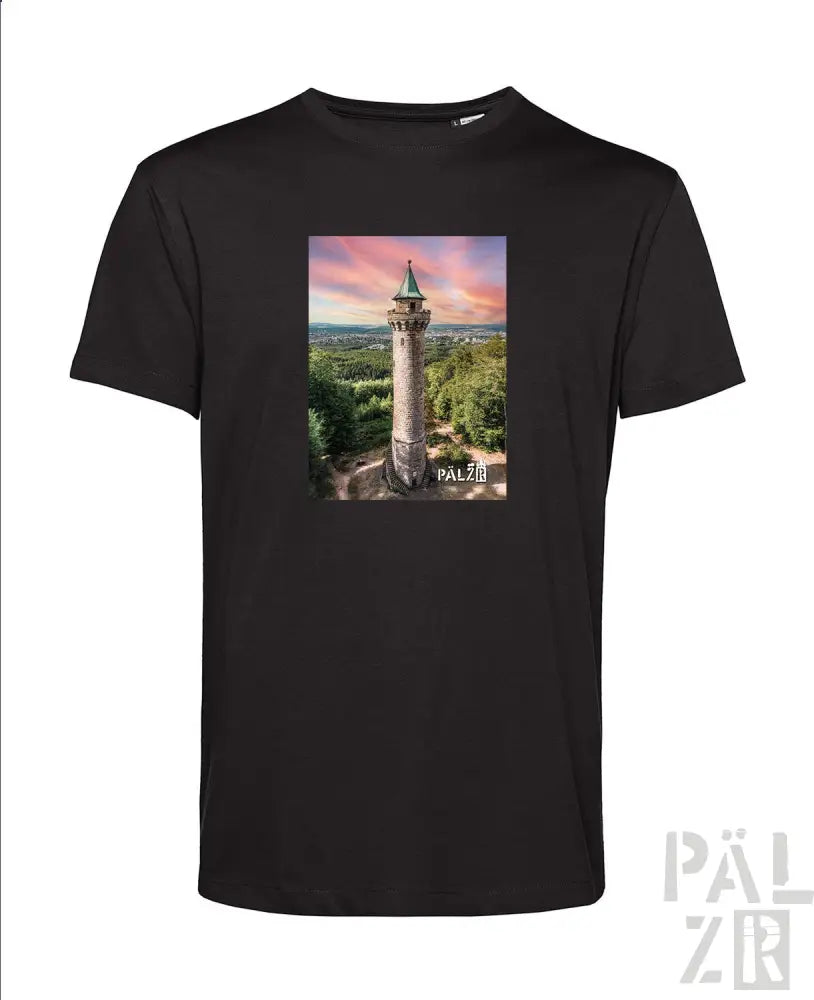 Schwarzes T-Shirt mit Turm-Grafikdesign, das eine grüne und braune Struktur vor einem pinken Himmel zeigt.