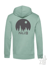 Ein weicher mintgrüner zipper mit dunkelgrauem kreisgrafik motiv bäume sterne mond und pälzr logo männer model