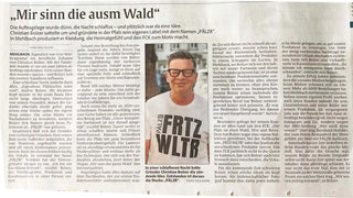 Ein lächelnder Mann trägt Brille und ein weißes T-Shirt.