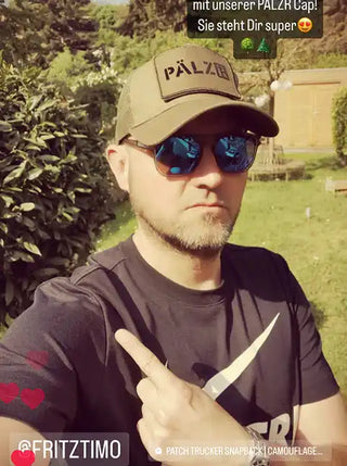 Ein Mann trägt eine grüne PÄLZR Baseballkappe mit Mesh-Rückseite und reflektierende Sonnenbrille.