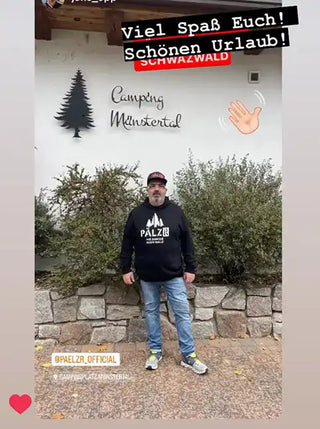 Mann in lässiger Kleidung steht vor einem Schild »Camping Müstertal«.