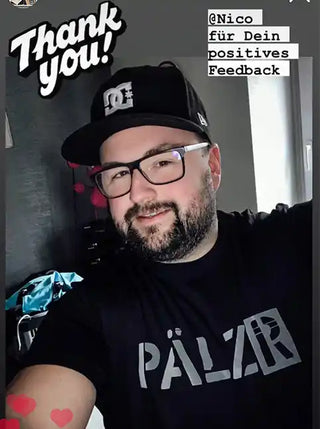 Lächelnder Mann in einer schwarzen Baseballkappe und Brille.