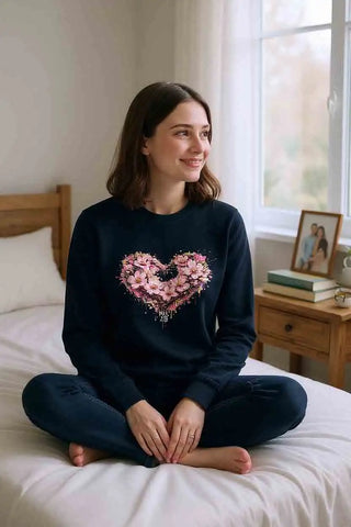 Ein marineblaues langärmliges Sweatshirt mit einem lebendigen pinken Blumenherz-Design auf der Vorderseite.