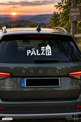 Weißer pälzer autoaufkleber mit burgen-silhouette auf der heckscheibe eines dunkelgrünen skoda kodiaq suv