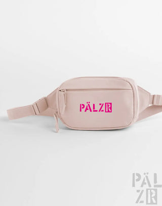 Ein blush pink palzr studio bag mit einem auffälligen magenta logo und verstellbarem riemen