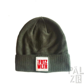 Olivgrüner Beanie mit rot-weißem ’frtz wltr’-Patch, aus geripptem Strickmaterial gefertigt.