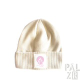Cremeweiße gerippte Mütze mit einem pinken Logo-Patch.