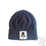 Marineblaue Beanie mit Totenkopf und Kreuzknochen-Aufnäher, gerippte Textur.