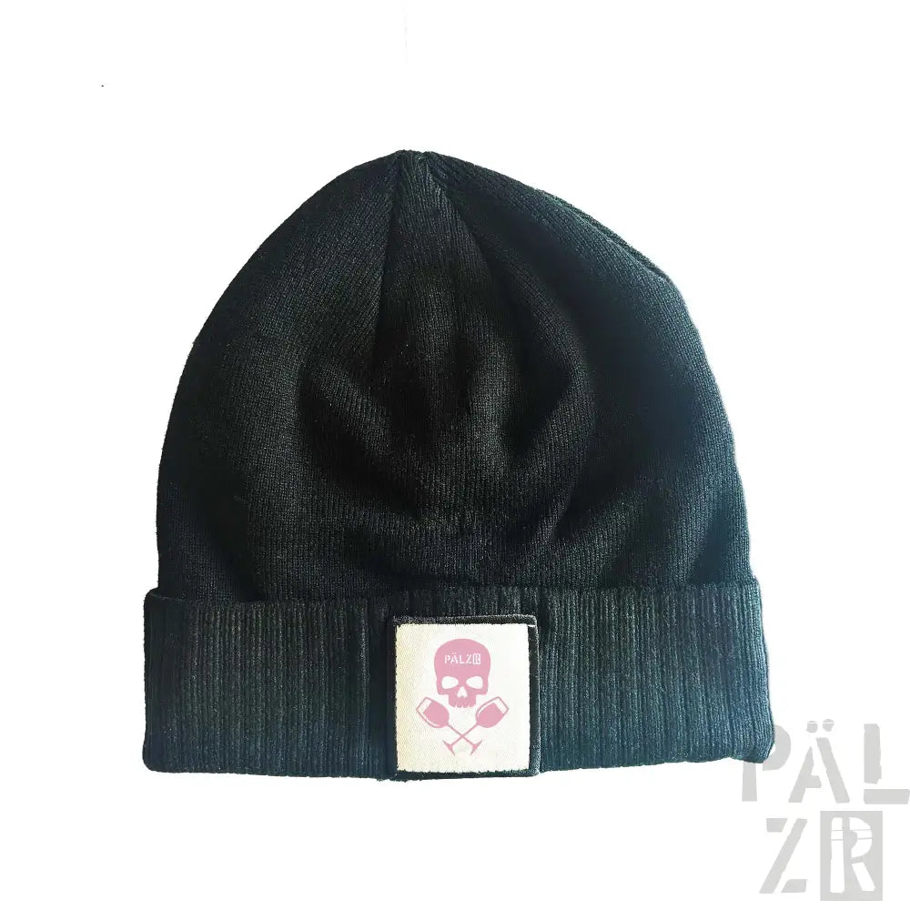 Schwarze gerippte Mütze mit Totenkopf-Patch und pinkem Kreuzknochen-Design.