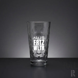 Klares Glas-Pint-Glas mit einem texturierten, blasenartigen Muster und weißem geprägtem Schriftzug, der ’pälz fritz wltr’ lautet.