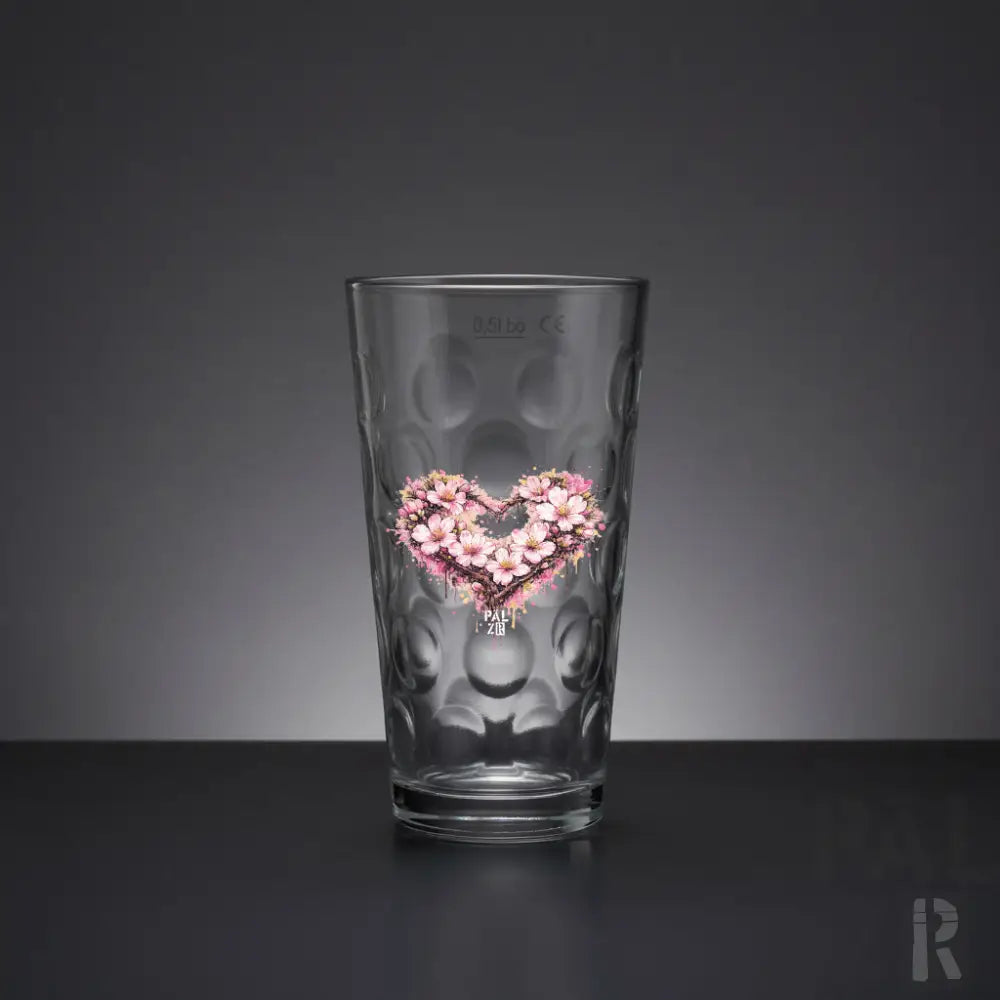 Klares Glas-Pint-Glas mit einer texturierten, blasenartigen Oberfläche und einem gedruckten Design eines rosa Kirschblüten-Herzens auf der Seite.
