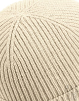 Cremeweiße Strickmütze mit gerippter Textur und leicht gefaltetem Rand.