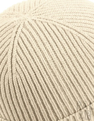 Cremeweiße Strickmütze mit gerippter Textur und leicht gefaltetem Rand.