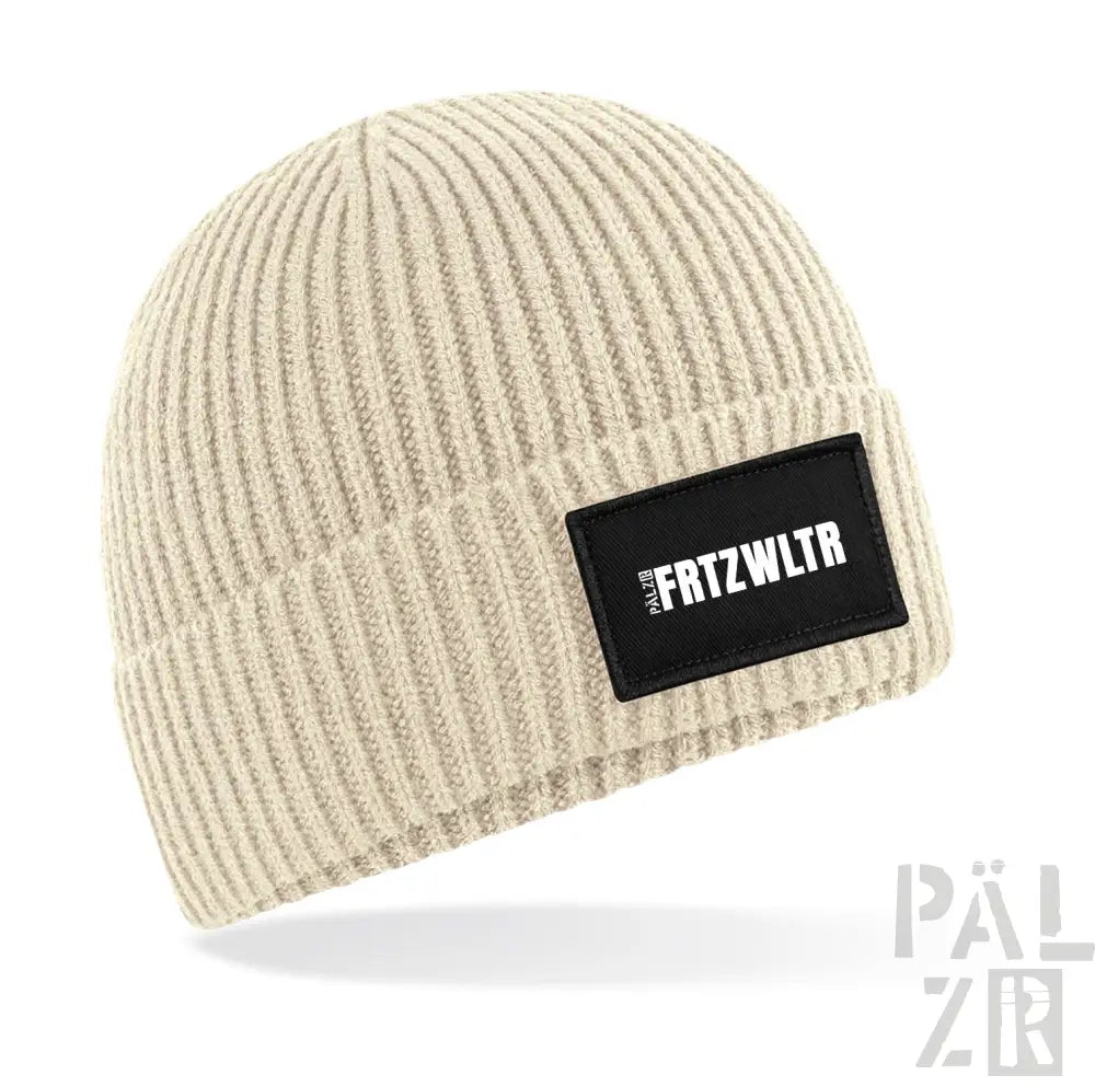 Cremeweiße Beanie mit schwarzem Patch und weißem Text ’fritzwltr’ darauf.