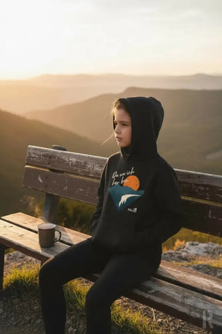 Schwarzes Hoodie mit einem Grafikdruck einer orangenen Sonne über blauen Bergen und weißem Text darüber
