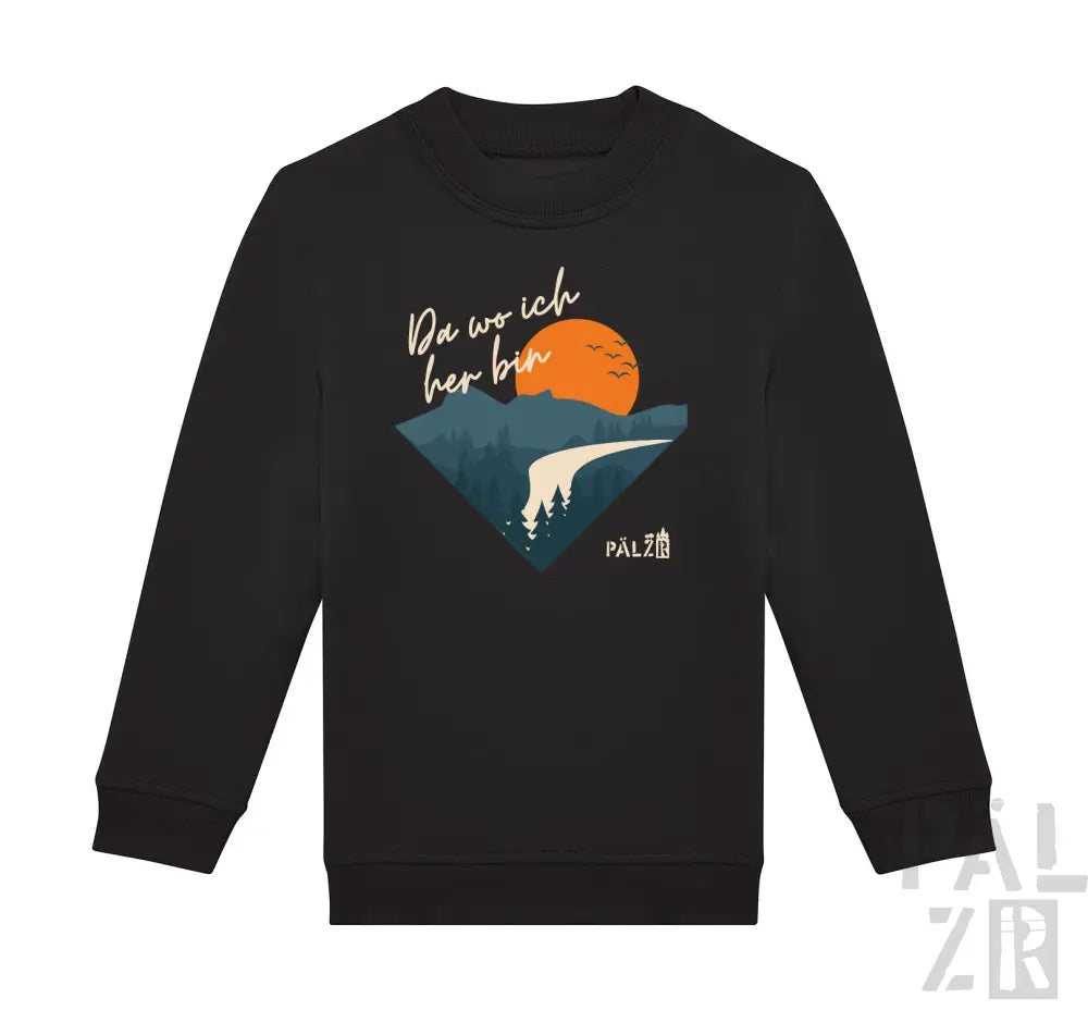 Schwarzes Langarm-Sweatshirt mit einem dreieckigen Grafikmotiv von Bergen, einer orangenen Sonne mit Vögeln und dem Text ’da wo ich her bin’ in weißer Schrift.