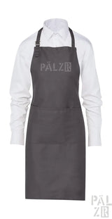 Dunkelgraue Schürze aus Kohle mit verstellbarem Nackenschnur und Vordertasche, mit dem ‚palzr‘-Logo.