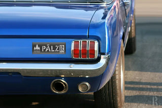 Blaues Ford Mustang-Auto aus den 1960er Jahren mit Chromdetails und Rückleuchten.