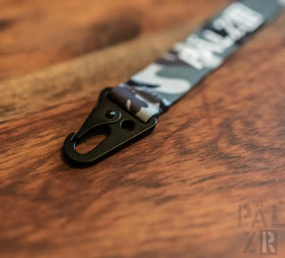 Tarnungsschleife mit schwarzer Klippe und Text ’palz’ auf einer Holzoberfläche.