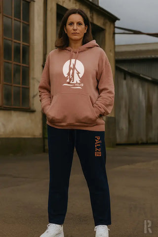 Rosa-pink Hoodie mit Grafikdesign, dunkelblaue Jogginghose mit ’palabr’ Logo.