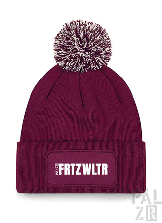 Bordeauxfarbene Mütze mit weißem Bommel und ’frtzwltr’-Patch, palzbe Marke.