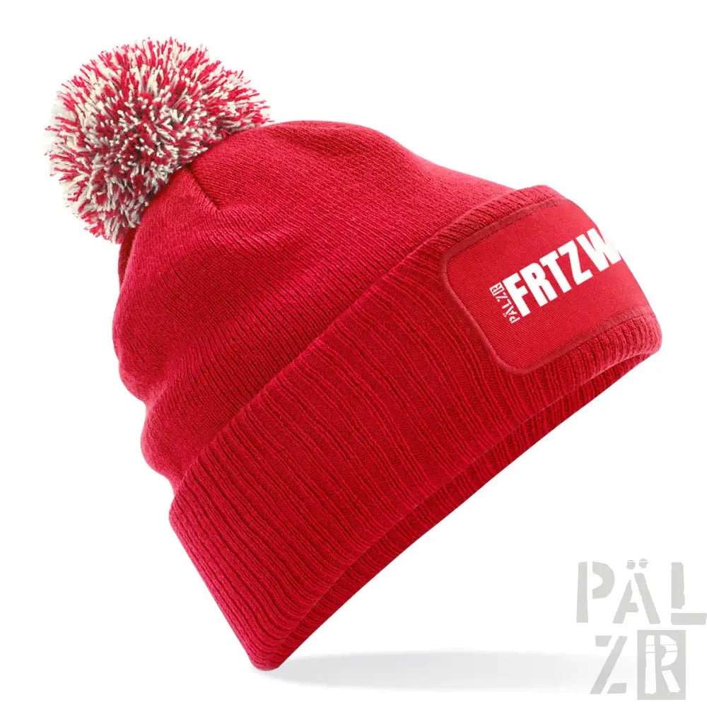 Roter gestrickter Beanie mit weißem Bommel und ’frtzw’-Patch.