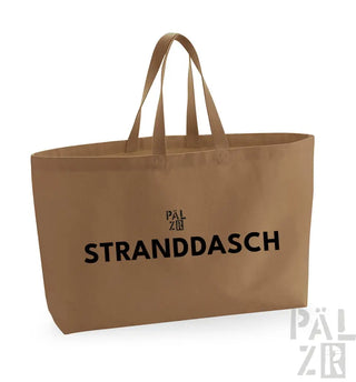Beige Leinwand-Tragetasche mit schwarzem Text und Griffen, markiert ’stranddasch’ von pälzr.
