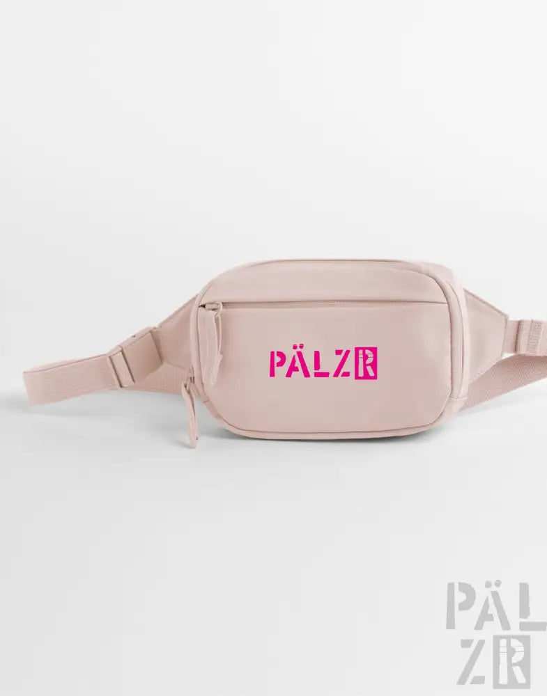 Ein blush pink palzr studio bag mit einem auffälligen magenta logo und verstellbarem riemen